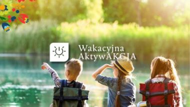 Zdjęcie trojga dzieci siedzących na pomoście nad jeziorem, patrzących w stronę wody. Dzieci mają plecaki turystyczne, a jedno z nich trzyma rękę przy czole, jakby wypatrywało czegoś w oddali. W tle widać zieloną roślinność i odbijające się w wodzie słońce. W lewym górnym rogu kolorowe, ludowe motywy kwiatowe. Na środku zdjęcia widnieje biały napis i ikona słońca: „Wakacyjna AktywAKCJA”